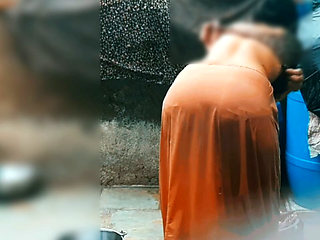 The desi sister-in-law of the village opened the drenched saree and took a bath in the open bathroom.